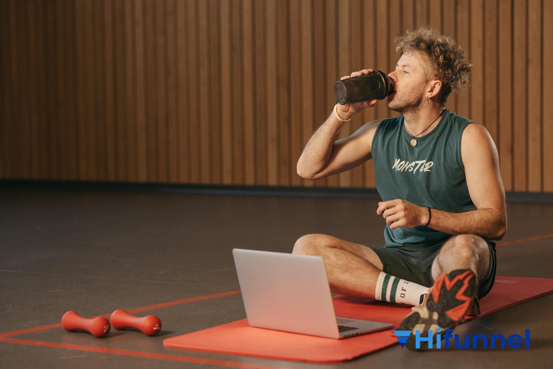 Coach fitness online - huấn luyện viên làm việc trên laptop tại bãi biển